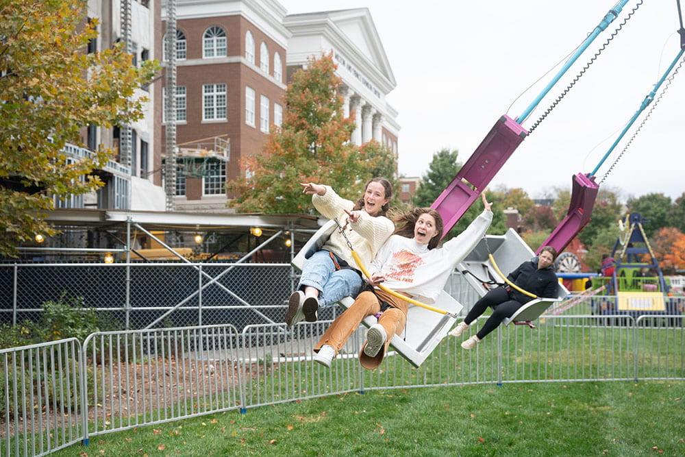 two students riding the spinning swing ride during a day to dream